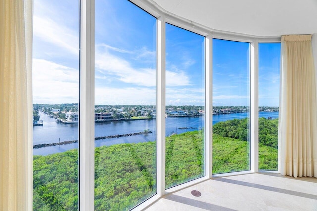 unfurnished sunroom featuring a water view and a wealth of natural light