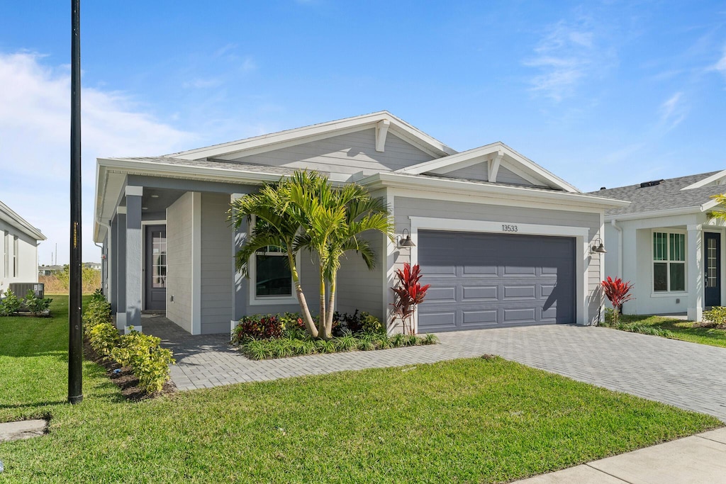 ranch-style house featuring a garage and a front lawn