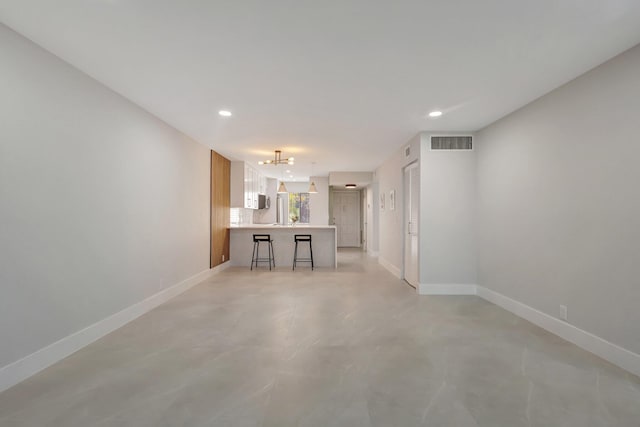 unfurnished living room featuring a notable chandelier