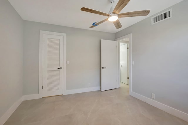 unfurnished bedroom with ceiling fan and a closet