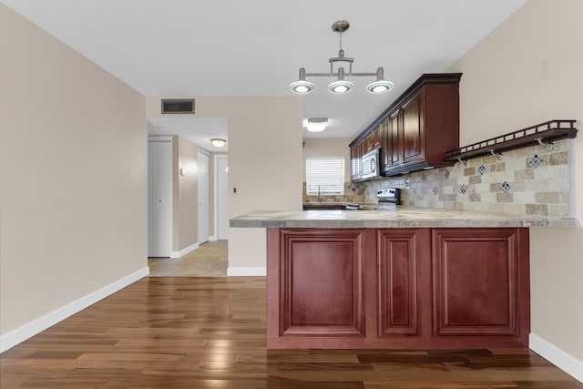 kitchen with an inviting chandelier, tasteful backsplash, decorative light fixtures, dark hardwood / wood-style flooring, and stainless steel appliances