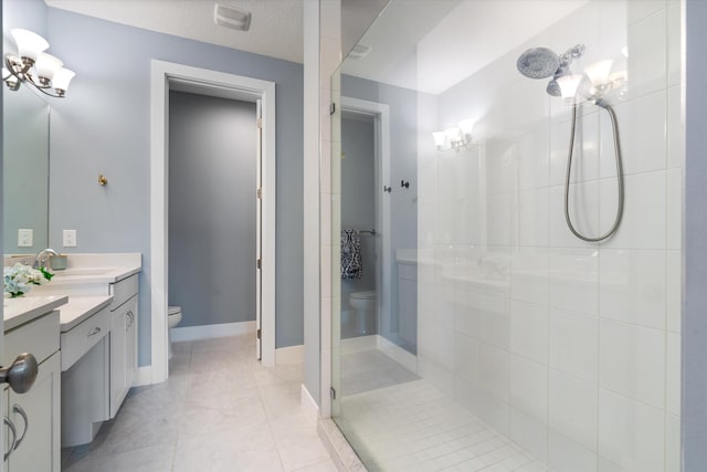 bathroom with tiled shower, vanity, a textured ceiling, tile patterned floors, and toilet