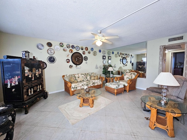 living room with ceiling fan, a textured ceiling, and light tile patterned floors