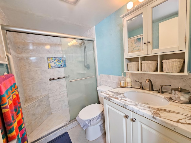 bathroom with vanity, toilet, and a shower with door