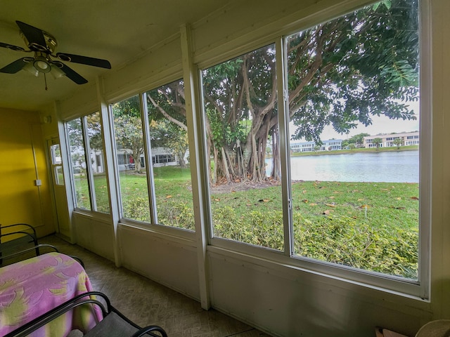 unfurnished sunroom featuring a water view, a wealth of natural light, and ceiling fan