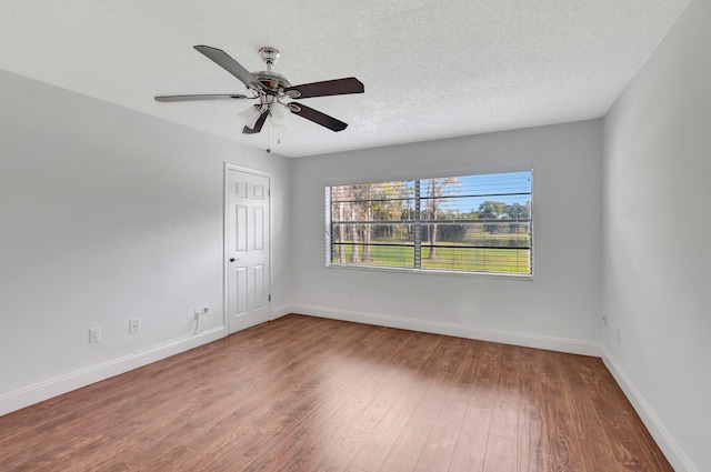 empty room with ceiling fan, hardwood / wood-style flooring, and a textured ceiling