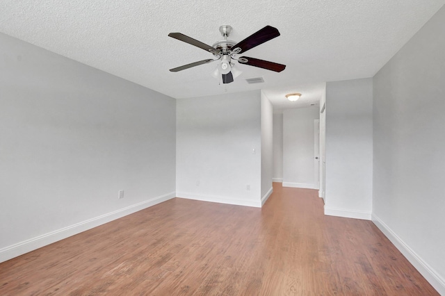 empty room featuring ceiling fan, hardwood / wood-style floors, and a textured ceiling