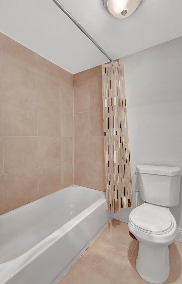 bathroom with shower / bathtub combination with curtain, tile patterned floors, and toilet