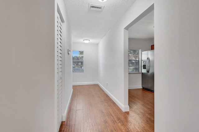 hall featuring hardwood / wood-style flooring and a textured ceiling