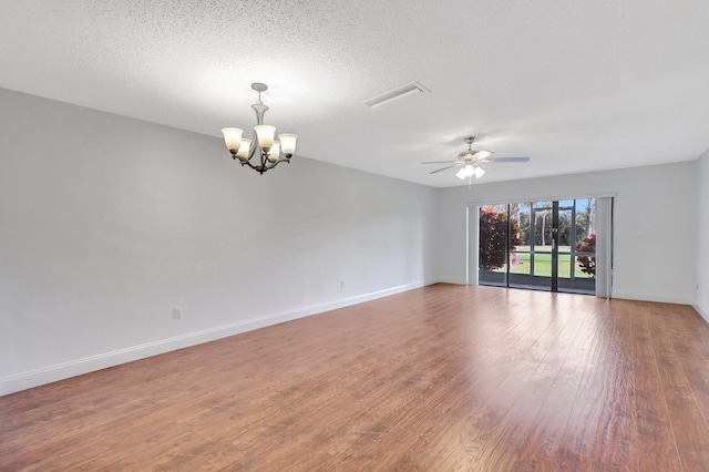 unfurnished room with hardwood / wood-style floors, ceiling fan with notable chandelier, and a textured ceiling