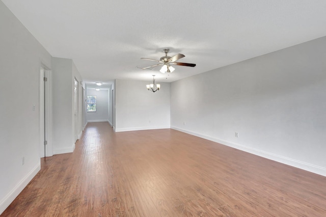 empty room featuring wood-type flooring and ceiling fan with notable chandelier