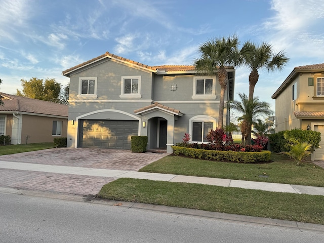 mediterranean / spanish home with a garage and a front yard