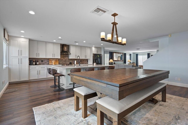 dining space with dark hardwood / wood-style floors, sink, and a chandelier