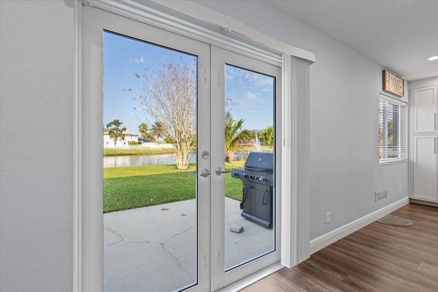 doorway to outside with a water view, french doors, and hardwood / wood-style flooring