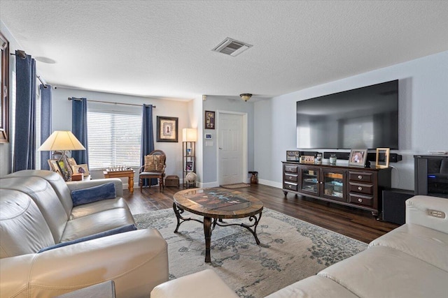 living room featuring dark wood-type flooring and a textured ceiling