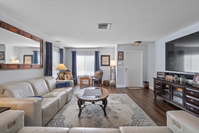 living room featuring a textured ceiling and dark hardwood / wood-style flooring