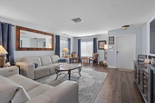 living room featuring dark hardwood / wood-style floors and a textured ceiling