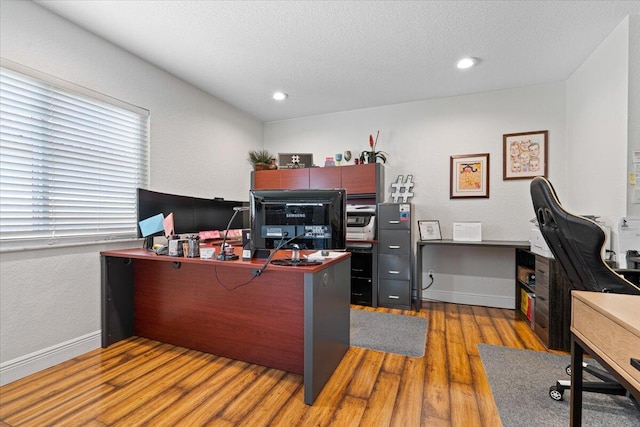 office area with wood-type flooring and a textured ceiling