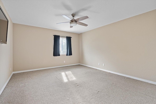 empty room featuring ceiling fan and carpet