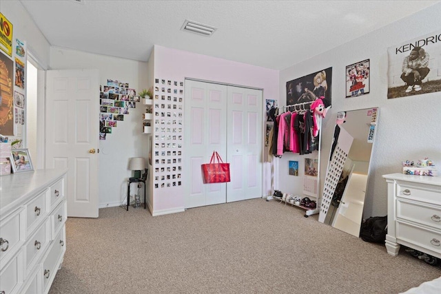 bedroom with light colored carpet, a closet, and a textured ceiling