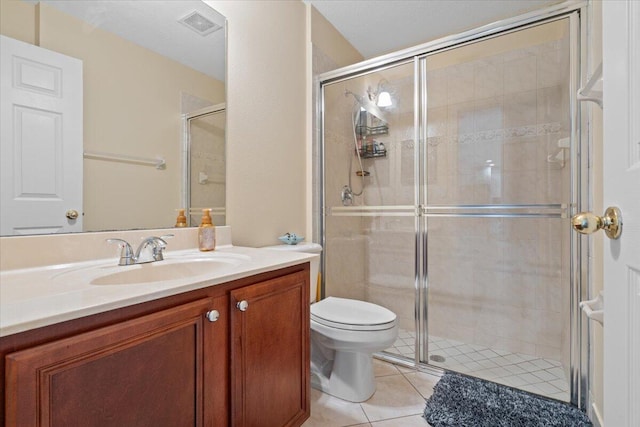 bathroom with vanity, a shower with shower door, tile patterned floors, and toilet