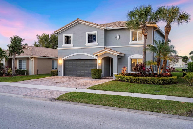 view of front of home with a yard and a garage