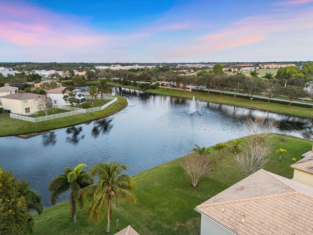 aerial view at dusk featuring a water view