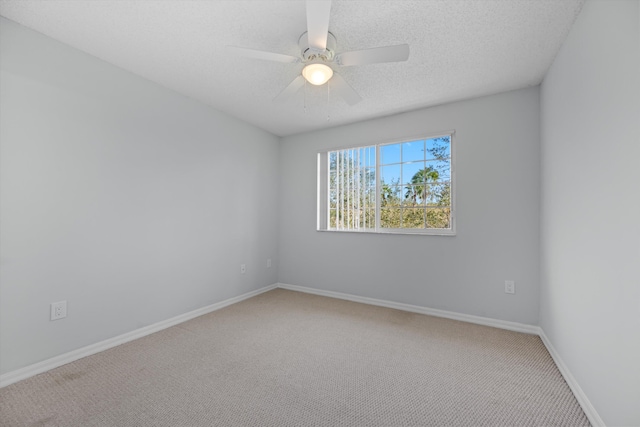 carpeted spare room with ceiling fan and a textured ceiling