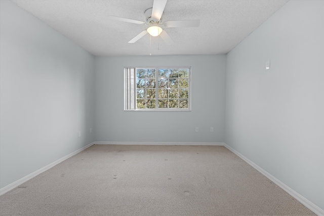 spare room featuring ceiling fan, carpet, and a textured ceiling