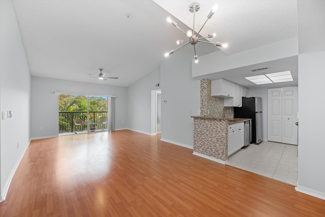 kitchen with tasteful backsplash, light wood-type flooring, stainless steel appliances, ceiling fan with notable chandelier, and white cabinets