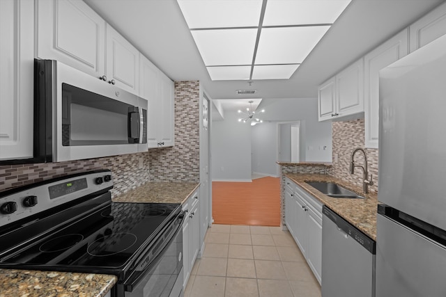 kitchen with white cabinetry, appliances with stainless steel finishes, sink, and stone countertops