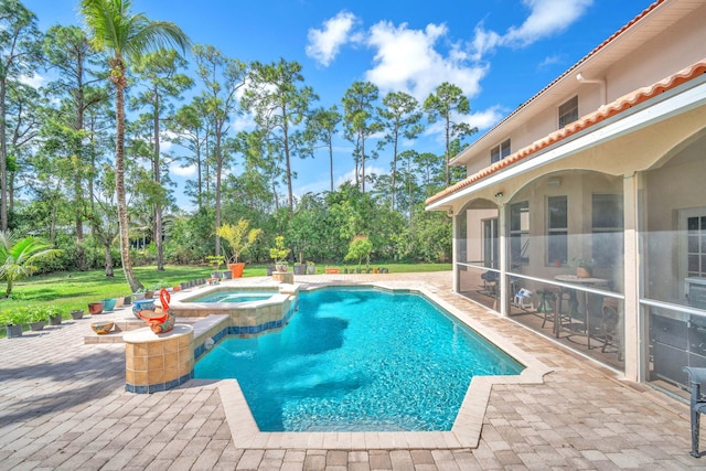 view of swimming pool featuring a pool with connected hot tub, a patio area, and a sunroom