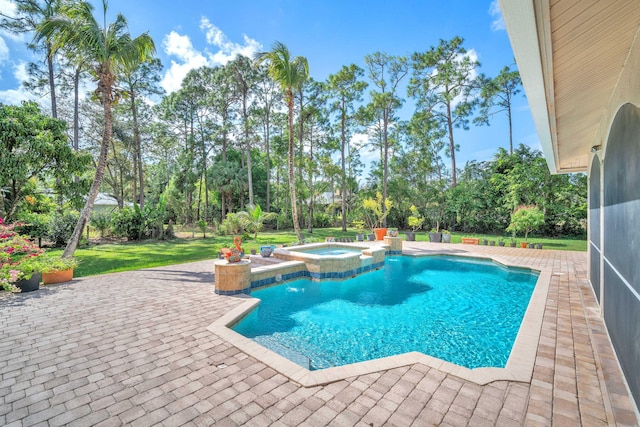 view of swimming pool with a pool with connected hot tub, a patio, and a lawn