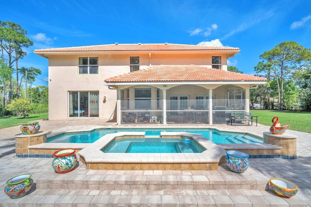 rear view of property with a patio, a tile roof, a pool with connected hot tub, a sunroom, and stucco siding