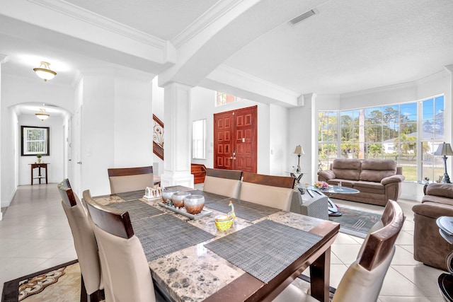 dining area featuring visible vents, decorative columns, arched walkways, and light tile patterned flooring