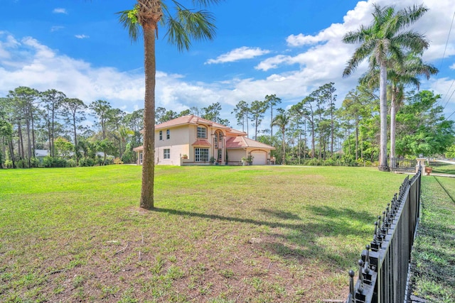 view of yard featuring an attached garage and fence