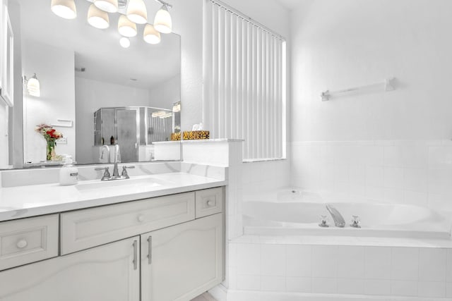 bathroom featuring a garden tub, a shower stall, and vanity