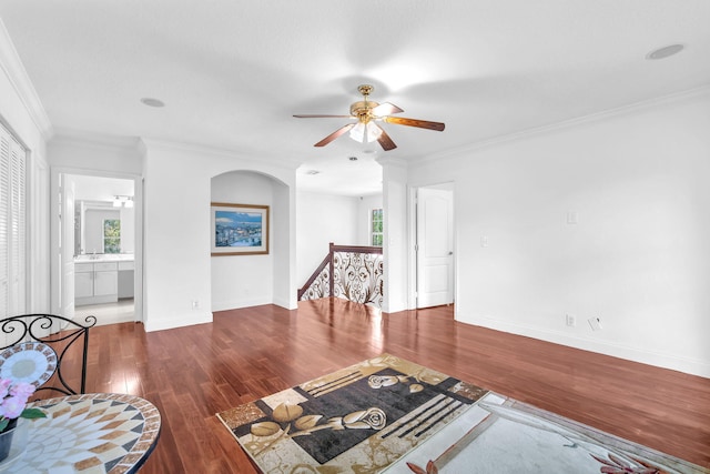 living room with ornamental molding, dark wood-type flooring, baseboards, and a healthy amount of sunlight