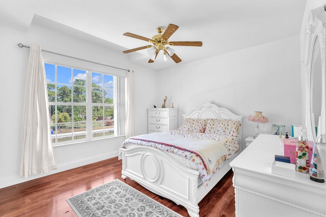 bedroom with dark wood-style floors, ceiling fan, and baseboards