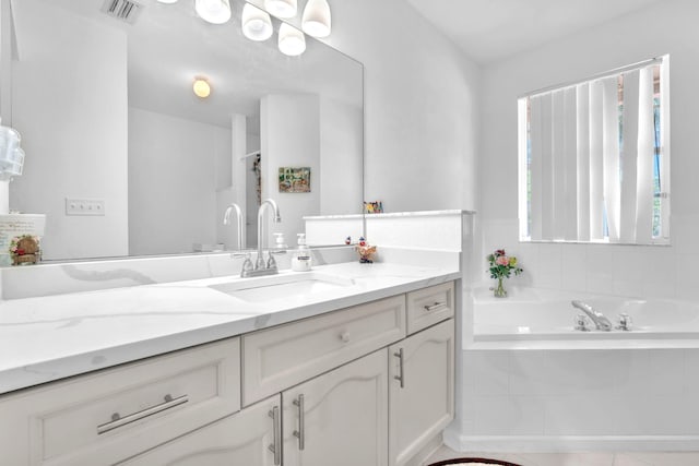 full bath featuring visible vents, a bath, and vanity