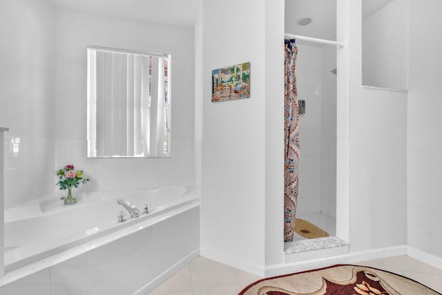 full bathroom featuring tile patterned flooring, a shower stall, baseboards, and a bath