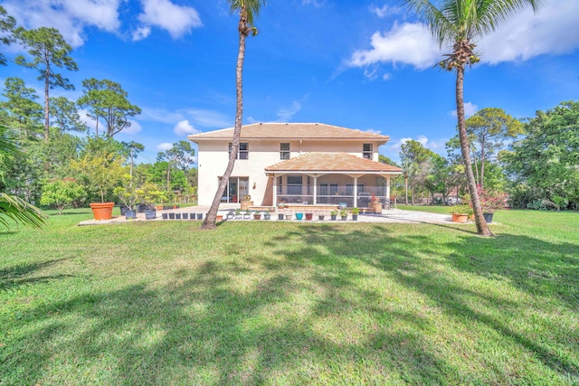 rear view of property with a yard and a patio