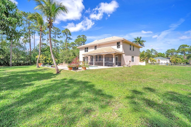 back of house featuring a yard, a patio area, and a sunroom