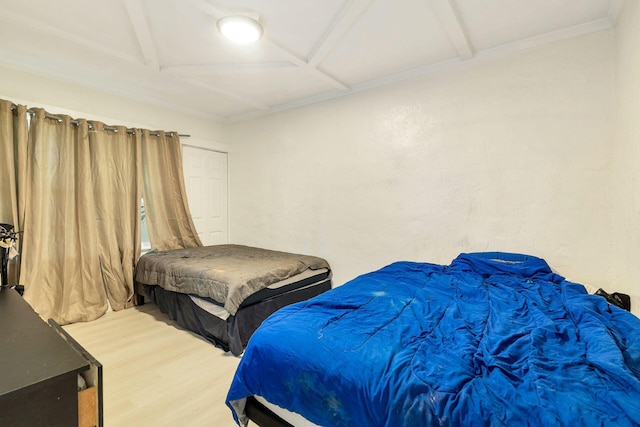 bedroom with crown molding, wood-type flooring, coffered ceiling, and beam ceiling