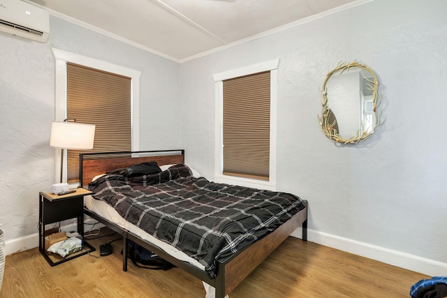 bedroom featuring a wall mounted air conditioner, ornamental molding, and hardwood / wood-style floors