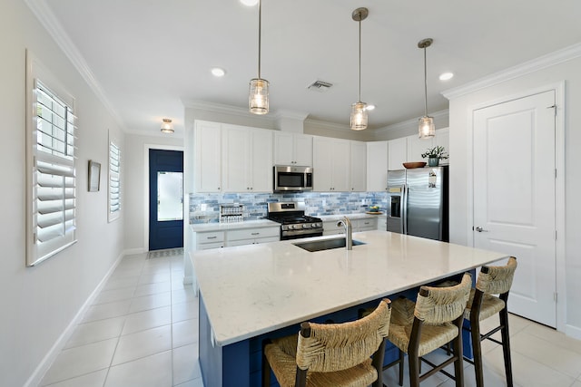 kitchen with appliances with stainless steel finishes, sink, white cabinets, a kitchen island with sink, and light tile patterned floors