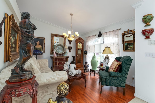 sitting room with wood-type flooring, ornamental molding, and an inviting chandelier