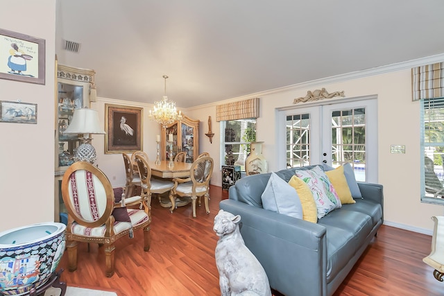 living room featuring french doors, dark hardwood / wood-style floors, an inviting chandelier, and crown molding