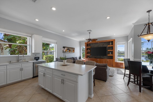 kitchen featuring pendant lighting, sink, dishwasher, a center island, and white cabinets