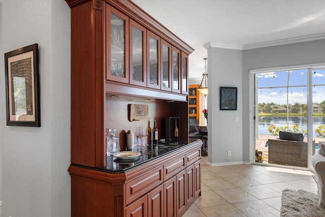 bar featuring light tile patterned floors, ornamental molding, and a water view